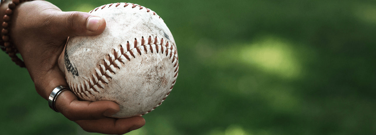 holding softball in grassy park